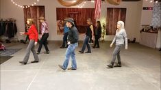 a group of people are dancing in a room with lights strung from the ceiling and american flags hanging on the walls