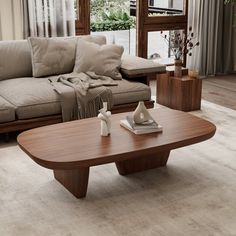 a living room with a couch, coffee table and vases on the floor in front of a window