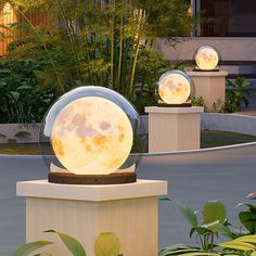 two large moon lamps sitting on top of pedestals