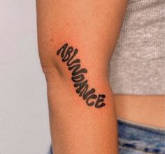 a woman's arm with the word dance tattooed on her left arm, in black ink