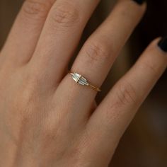 a woman's hand with a diamond ring on it