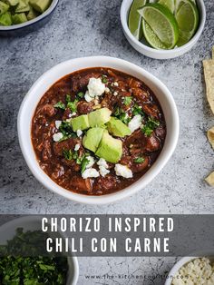 a bowl of chili con carne next to tortilla chips and avocado