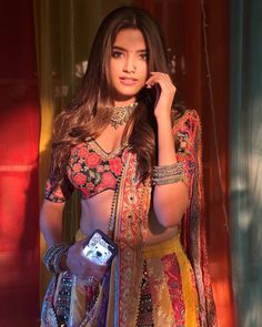 a beautiful woman in a colorful dress holding a cell phone