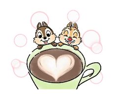 two chipmuns sitting on top of a coffee cup with a heart in the foam