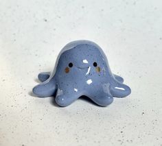 a blue ceramic figurine sitting on top of a white counter with speckles