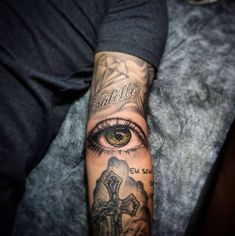 a man's arm with tattoos and an eye on it