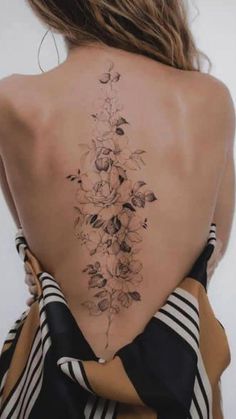 the back of a woman's neck with flowers on it