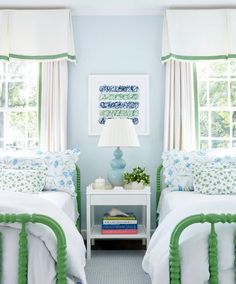 two twin beds in a bedroom with blue walls and green trim on the bedding