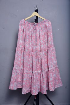 Elevate your wardrobe with this stunning Hand Block Printed Cotton Long Skirt, designed to combine comfort, style, and tradition. Perfect for every occasion, this skirt promises to add a touch of elegance to your ensemble. Here's why you'll love it: Size Details: Length: 38 inches / 96 cm Waist: 26 inches / 66 cm (fits up to 38 inches / 96 cm with elastic and belt tie) Flexible Fit: One Size Regular Customization: We are happy to customize this skirt according to your measurements. Please contact us with your specific size requirements. Key Features: Authentic Hand Block Printing: Each skirt is meticulously crafted using traditional hand block printing techniques, showcasing exquisite floral patterns in pink and white. This artisanal process ensures that every piece is unique and full of c Traditional Relaxed Maxi Skirt With Lining, Traditional Relaxed Lined Maxi Skirt, Traditional Flared Maxi Skirt For Spring, Traditional Tiered Maxi Skirt For Spring, Traditional Boho Print Skirt For Summer, Pink Bohemian Relaxed Maxi Skirt, Traditional Relaxed Fit Flared Maxi Skirt, Traditional Relaxed Flared Maxi Skirt, Traditional Flared Maxi Skirt