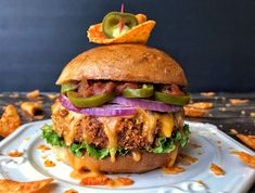 a cheeseburger with onions, lettuce and pickles on a plate