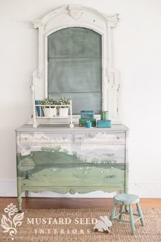 a green painted dresser in front of a white wall with a mirror above it and plants on top