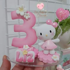 a hello kitty birthday cake topper on a plate