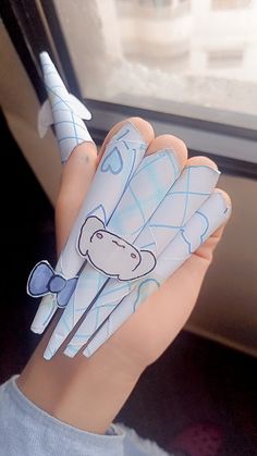 a hand holding an origami shaped animal on it's palm, with a window in the background