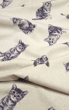 a cat print fabric with kittens on it's back and the background is off white