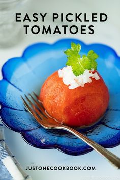 a blue plate topped with a tomato covered in sour cream and garnished with cilantro