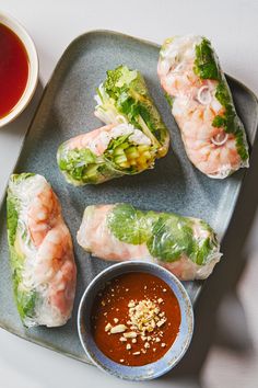 shrimp and lettuce wrapped in rice paper with dipping sauce on a plate next to it