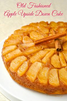 an old fashioned apple upside down cake on a white plate with cinnamon stick sticking out of it