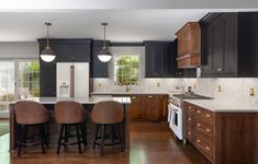 a kitchen with dark wood cabinets and white marble counter tops is pictured in this image