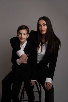 two people sitting on a chair posing for the camera