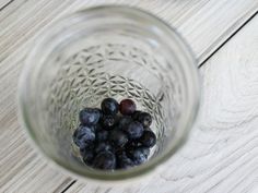 blueberries in a glass jar on a wooden table