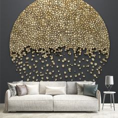 a living room with a couch, table and large wall art piece on the wall