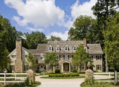 a large stone house surrounded by lush green trees