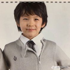 a young boy wearing a sweater and tie