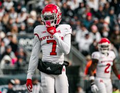 a football player wearing a red and white uniform is on the field during a game