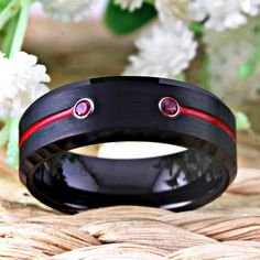 the new york rangers black ceramic ring with red and white diamonds is shown in front of flowers