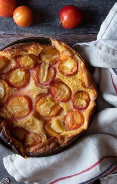 a pie with peaches on top sitting on a table