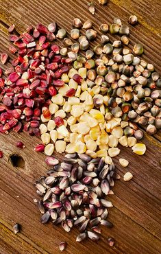 several different types of seeds on a wooden surface