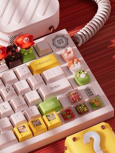 a computer keyboard sitting on top of a wooden table next to a yellow and red object