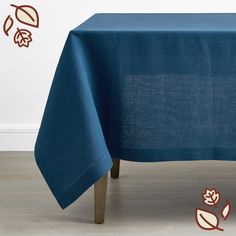 a blue tablecloth with leaves on it sitting in front of a white wall and floor