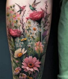 a woman's thigh with flowers and hummings on the side of her leg