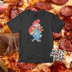 a black t - shirt with an image of a cartoon character on it and pizza slices in the background