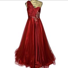 Mac Duggal Ball Gown. Red Color With Silver/Iridescent Embellishments. Pleated/Gathered Fabric On The Bodice. Mesh Overlay Fabric On The Skirt With Silky Fabric Underneath. One Shoulder Strap With Sweetheart Neckline. Zips In The Back. Size 16. Approx Measurements While Flat- Pit To Pit: 18.5', Length: 60", Waist: 16.5" Good Condition. Back Of Shoulder Strap Needs Mending To Attach It To The Dress Again. Some Nicks On Bodice Front And Back. A Few Pulls On Skirt. Flaws Are Minimal. See Photos. Red Evening Gown For Christmas, Red Christmas Evening Gown, Red Gown For Christmas Formal Occasion, Red Formal Evening Dress For Christmas, Elegant Christmas Gown For Formal Occasions, Elegant Christmas Formal Gown, Red Satin Embellished Evening Dress, Red Embellished Satin Evening Dress, Red Embellished Evening Ball Gown