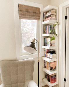 a white chair sitting next to a window filled with books