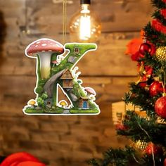 a christmas ornament shaped like the letter k with mushrooms and houses hanging from it