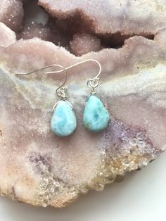 "A beautiful dainty polished and drilled  pair of Larimar earrings in a simple tear drop shape will be placed on a dainty sterling silver or 14k gold filled ear hooks.  These Larimar stone earrings have the most beautiful soothing blue shades. With its light blue and white swirls this will make the perfect piece of Larimar jewelry in your collection.  Each pendant differs from the next they are about 1/2\"  💙 sea and sky energies  💙 serenity  💙 relaxation  💙 worry stone  💙 emotional cleanser and healer  💙 helps restore connection with nature  Each pair will come in a pink velvet jewelry bag" Blue Larimar Dangle Earrings, Larimar Dangle Earrings For Gifts, Blue Larimar Earrings For Gift, Raw Rose Quartz Necklace, Larimar Earrings, Raw Stone Necklace, Blue Drop Earrings, Raw Crystal Jewelry, Raw Rose Quartz