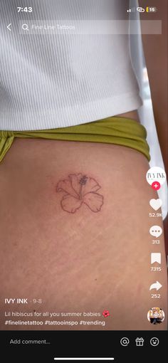 a woman's stomach with a flower tattoo on it