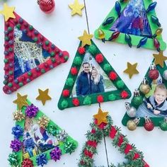 christmas ornaments are arranged on a table with photos and decorations around them, including trees