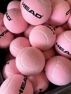 a pile of pink tennis balls with the word head on them in black lettering,