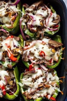 stuffed bell peppers with meat, cheese and vegetables in a casserole dish ready to be eaten