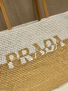 a brown and white bag with the word prada written on it