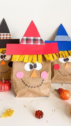 three paper bags with faces and noses on them, one is made to look like scarecrows