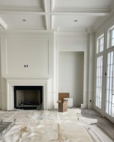 an empty living room with white walls and wood trimmings on the floor in front of a fireplace