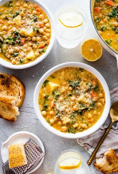 three bowls of soup with bread and lemon slices