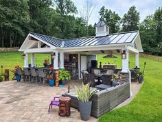 a patio with chairs, tables and an outdoor kitchen