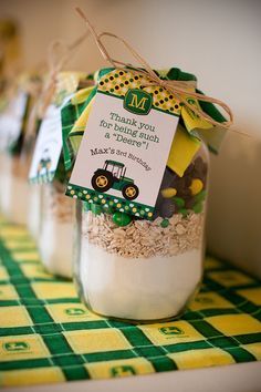 three jars filled with rice sitting on top of a green and yellow checkered table cloth