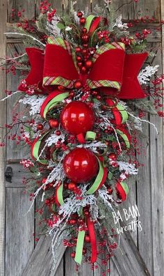 a red and green christmas wreath on the front door